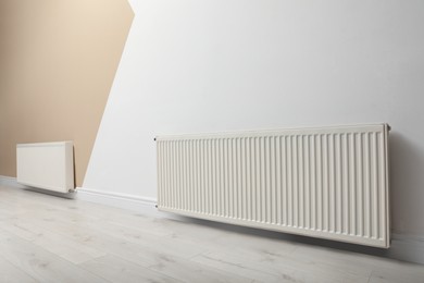 Photo of Modern radiators on color wall indoors. Central heating system