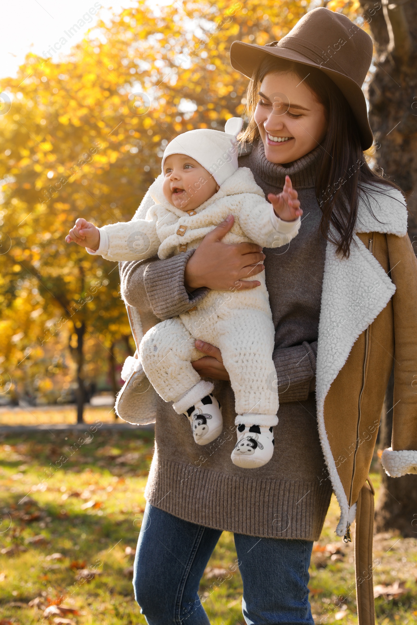 Photo of Happy mother with her baby daughter in park on sunny autumn day