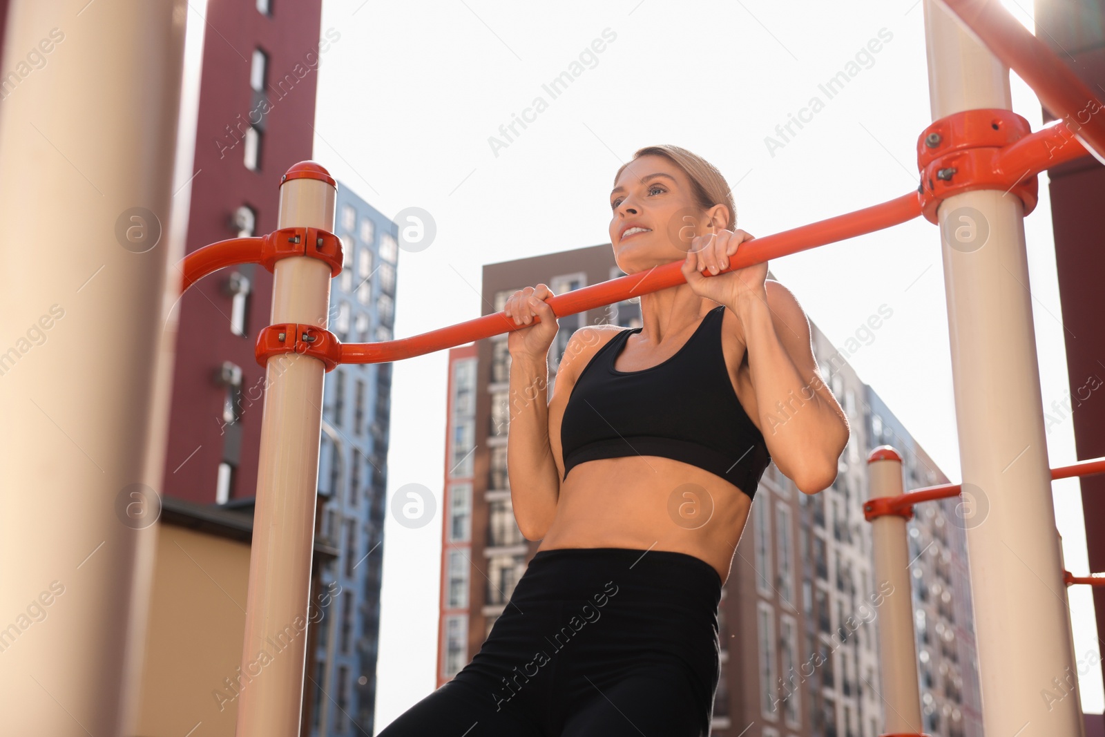 Photo of Woman doing pull ups at outdoor gym