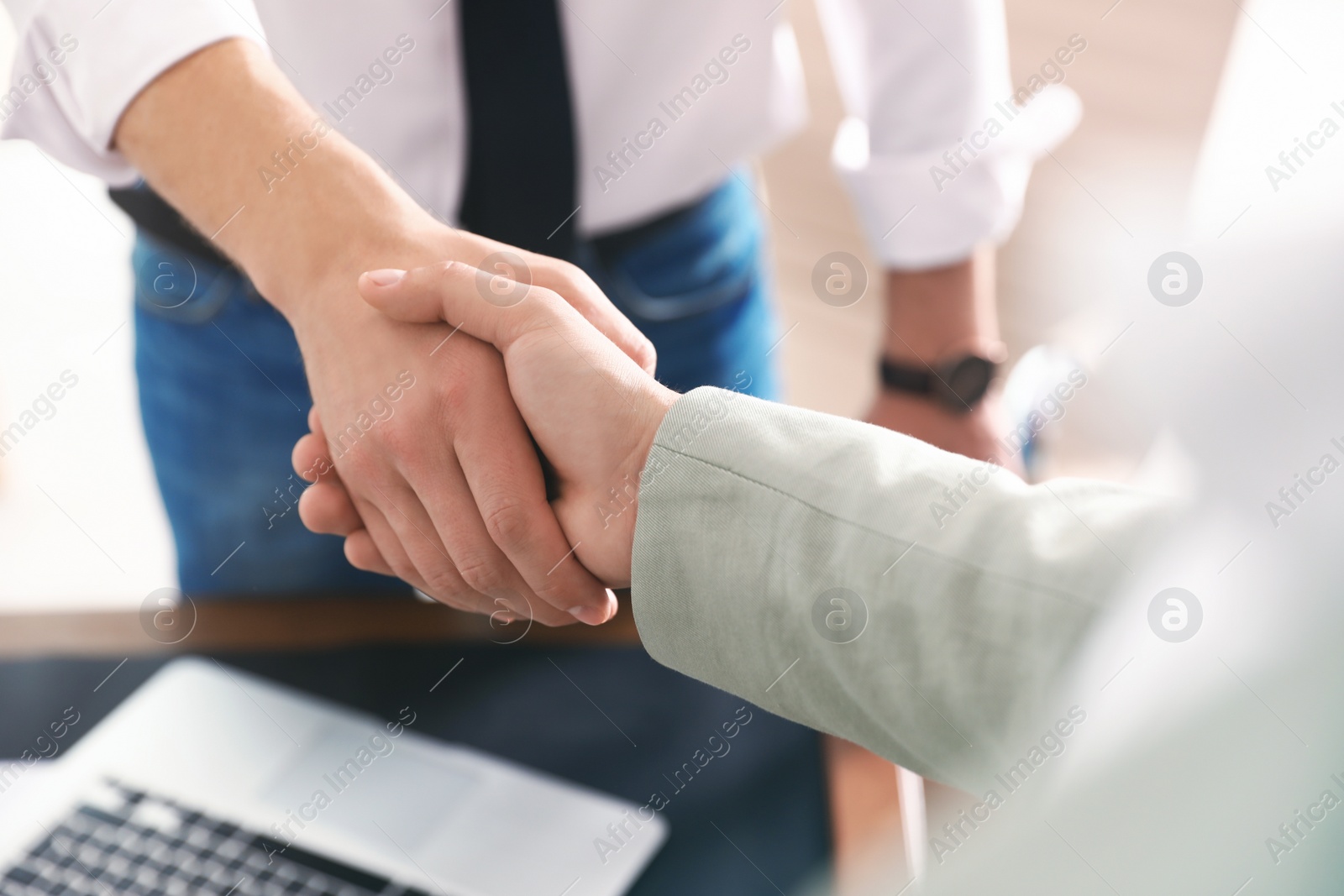 Photo of Business partners shaking hands after meeting, closeup