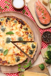 Photo of Delicious homemade quiche and ingredients on table, flat lay
