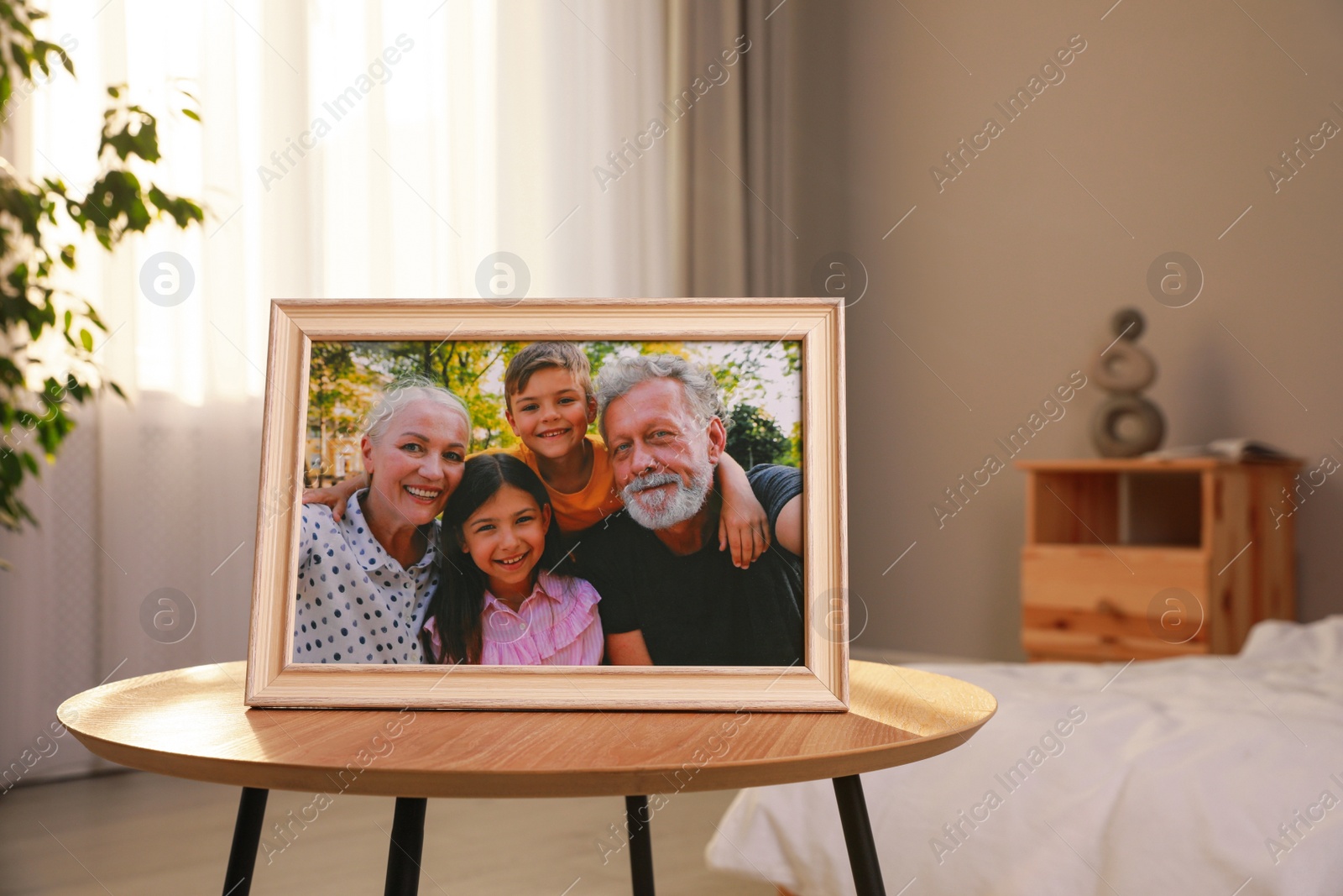 Photo of Framed family photo on wooden table in bedroom