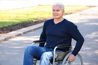 Photo of Senior man in wheelchair at park on sunny day