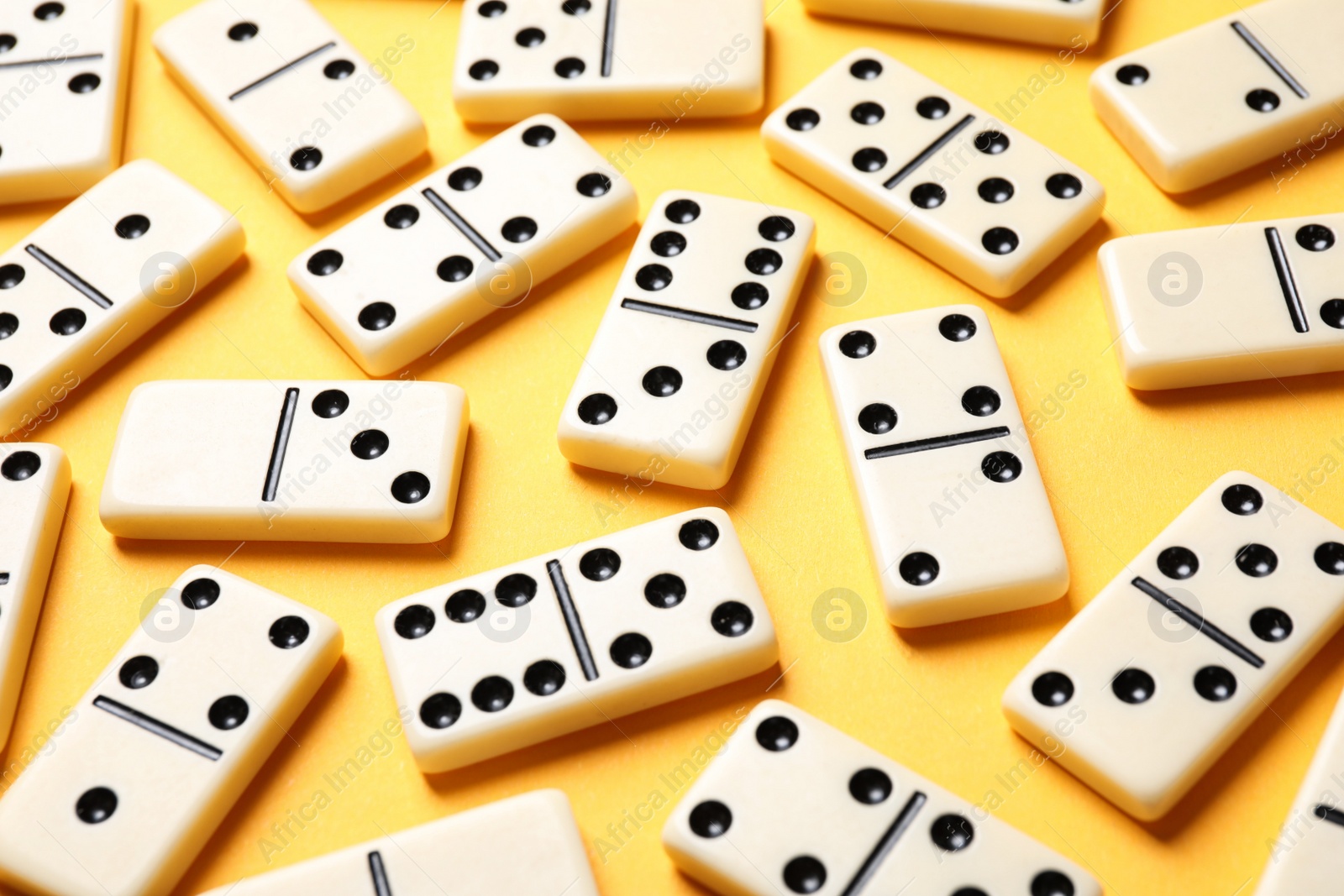 Photo of Set of classic domino tiles on yellow background