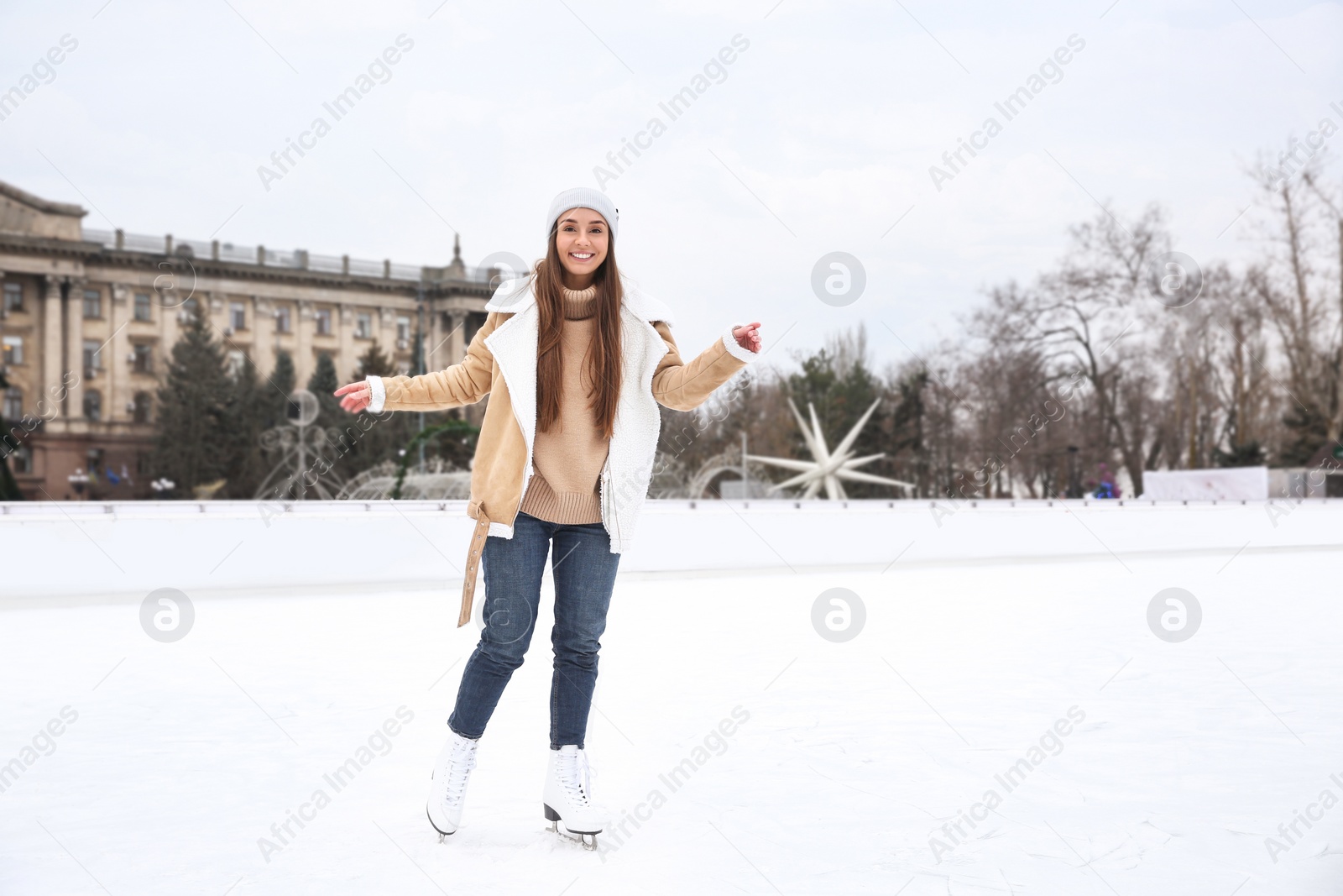 Image of Happy woman skating along ice rink outdoors. Space for text