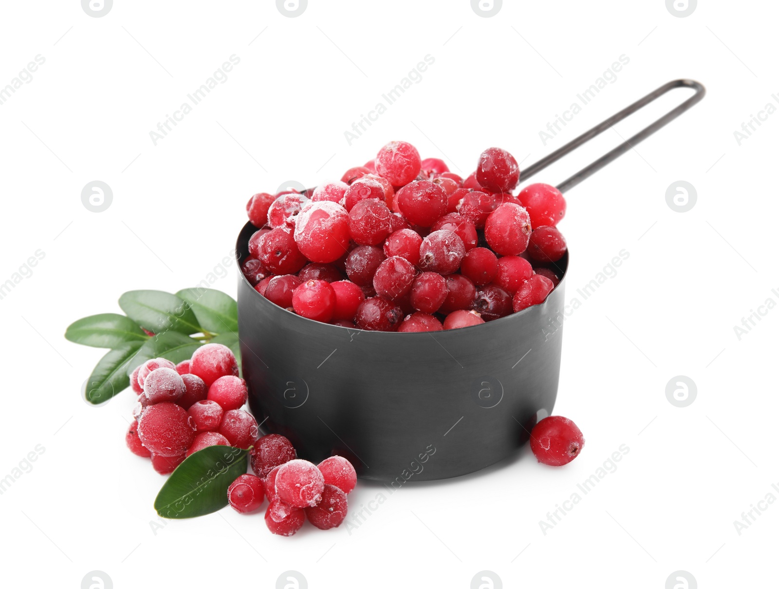 Photo of Frozen red cranberries in scoop and green leaves isolated on white