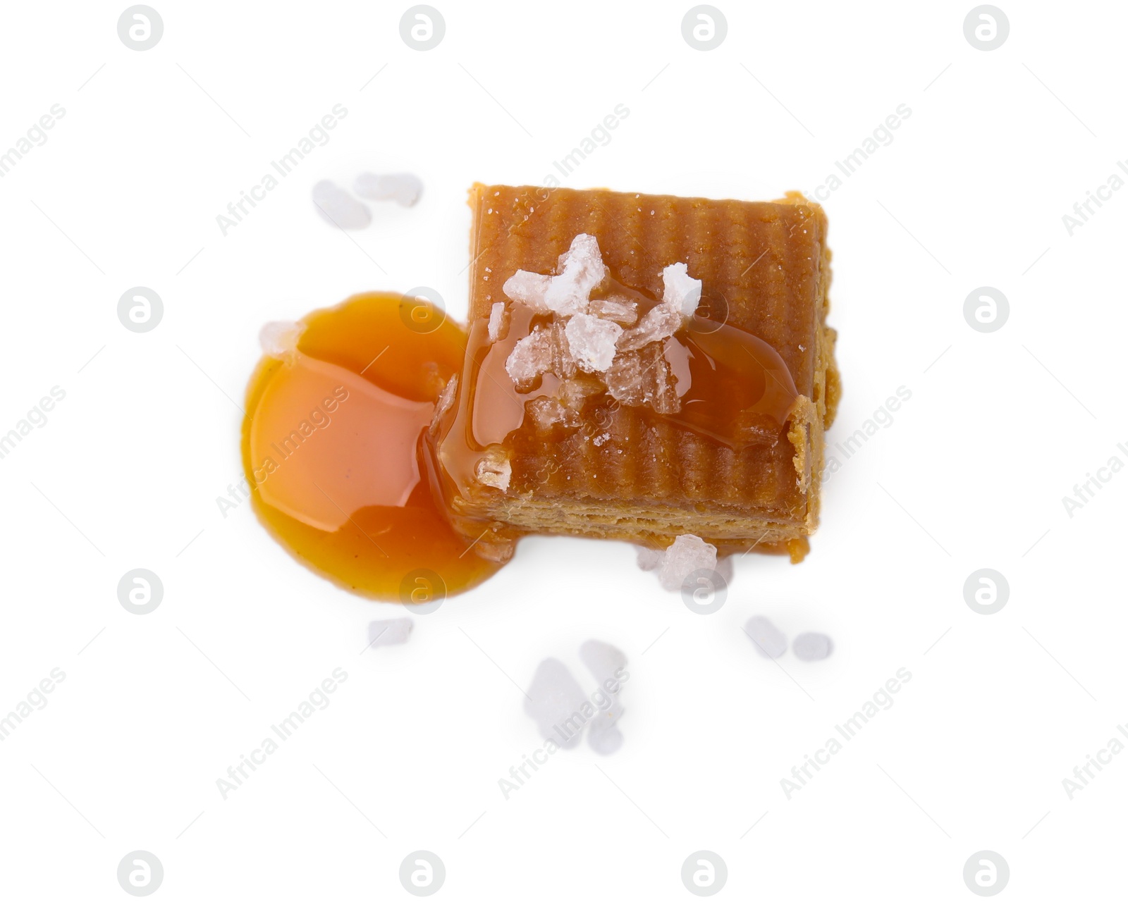 Photo of Yummy caramel candy and sea salt isolated on white, top view