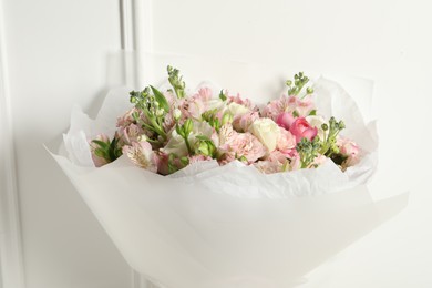 Photo of Beautiful bouquet of fresh flowers near white wall