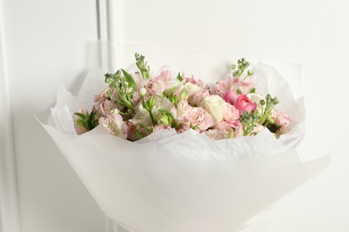 Beautiful bouquet of fresh flowers near white wall