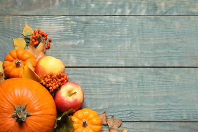 Photo of Flat lay composition with ripe pumpkins and autumn leaves on blue wooden table, space for text. Happy Thanksgiving day