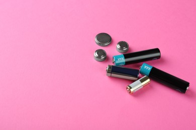 Image of Different types of batteries on pink background, space for text