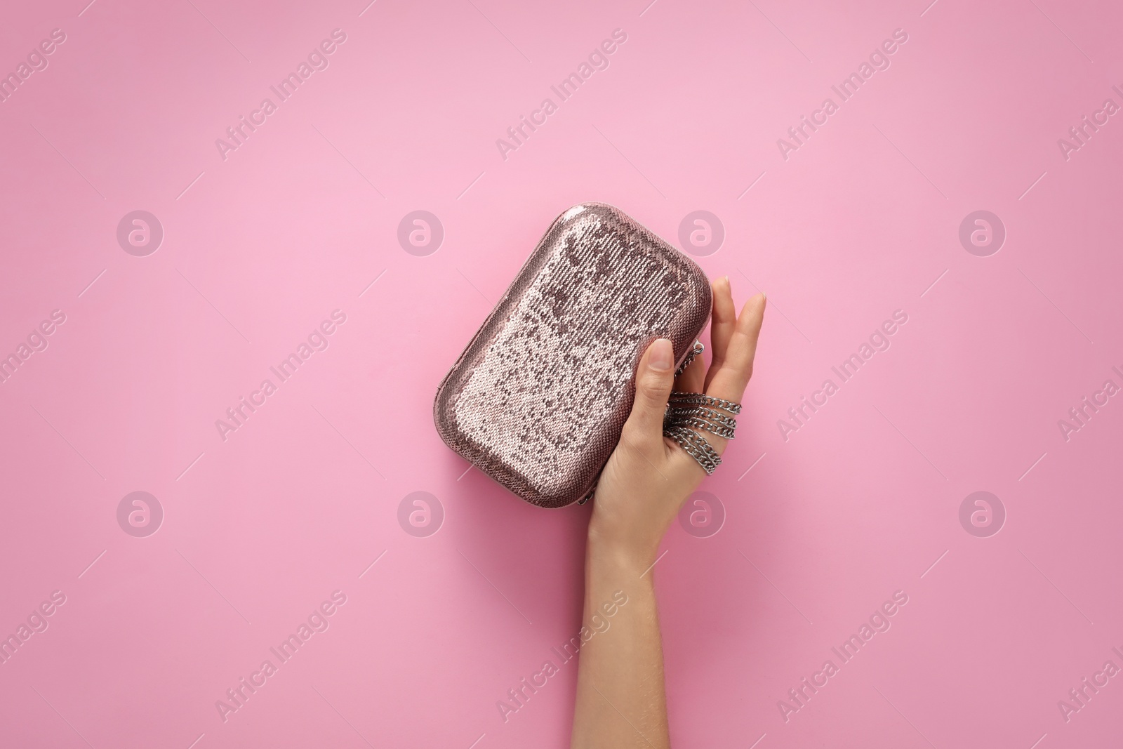 Photo of Woman holding stylish handbag on pink background, closeup