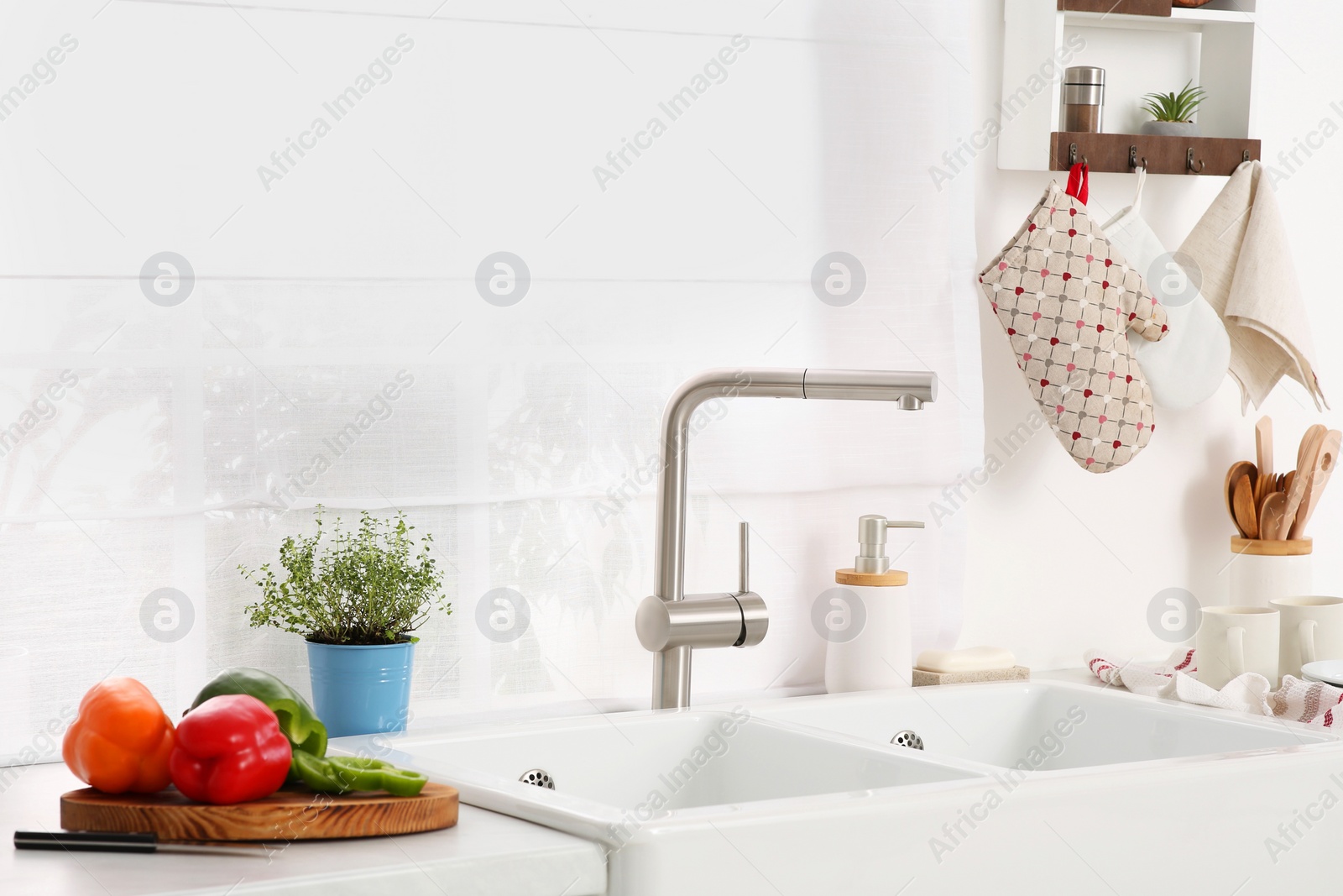 Photo of Kitchen counter with sinks, utensils and vegetables