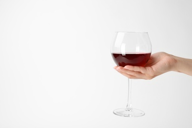 Photo of Woman holding glass of expensive red wine on white background