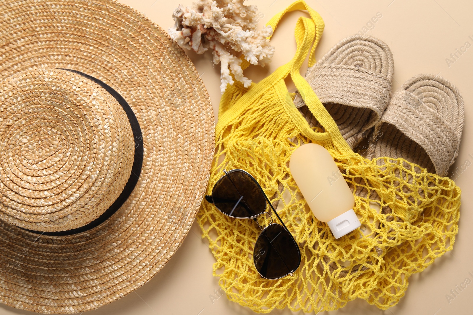 Photo of String bag and different beach accessories on beige background, top view