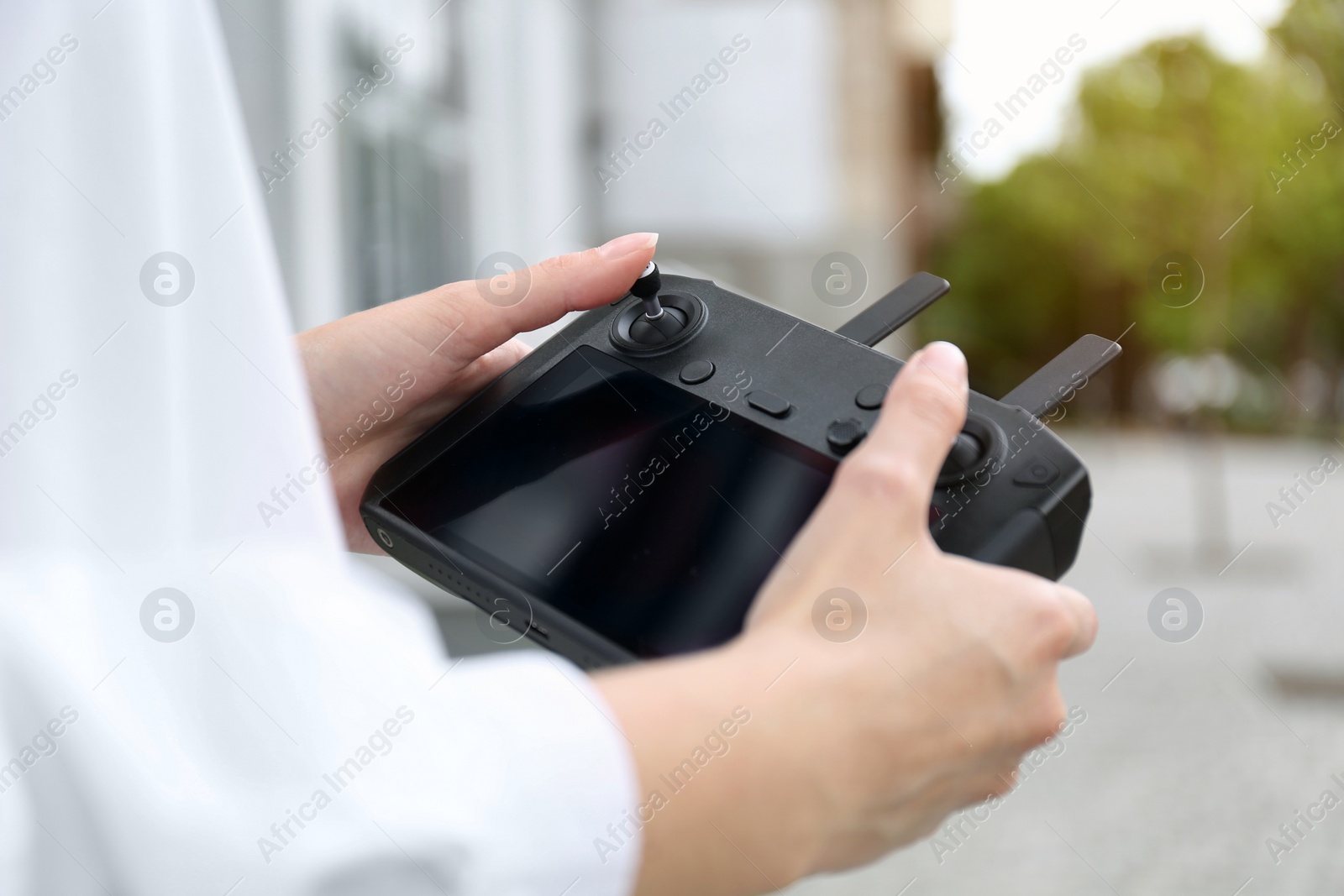 Photo of Woman with modern drone controller outdoors, closeup