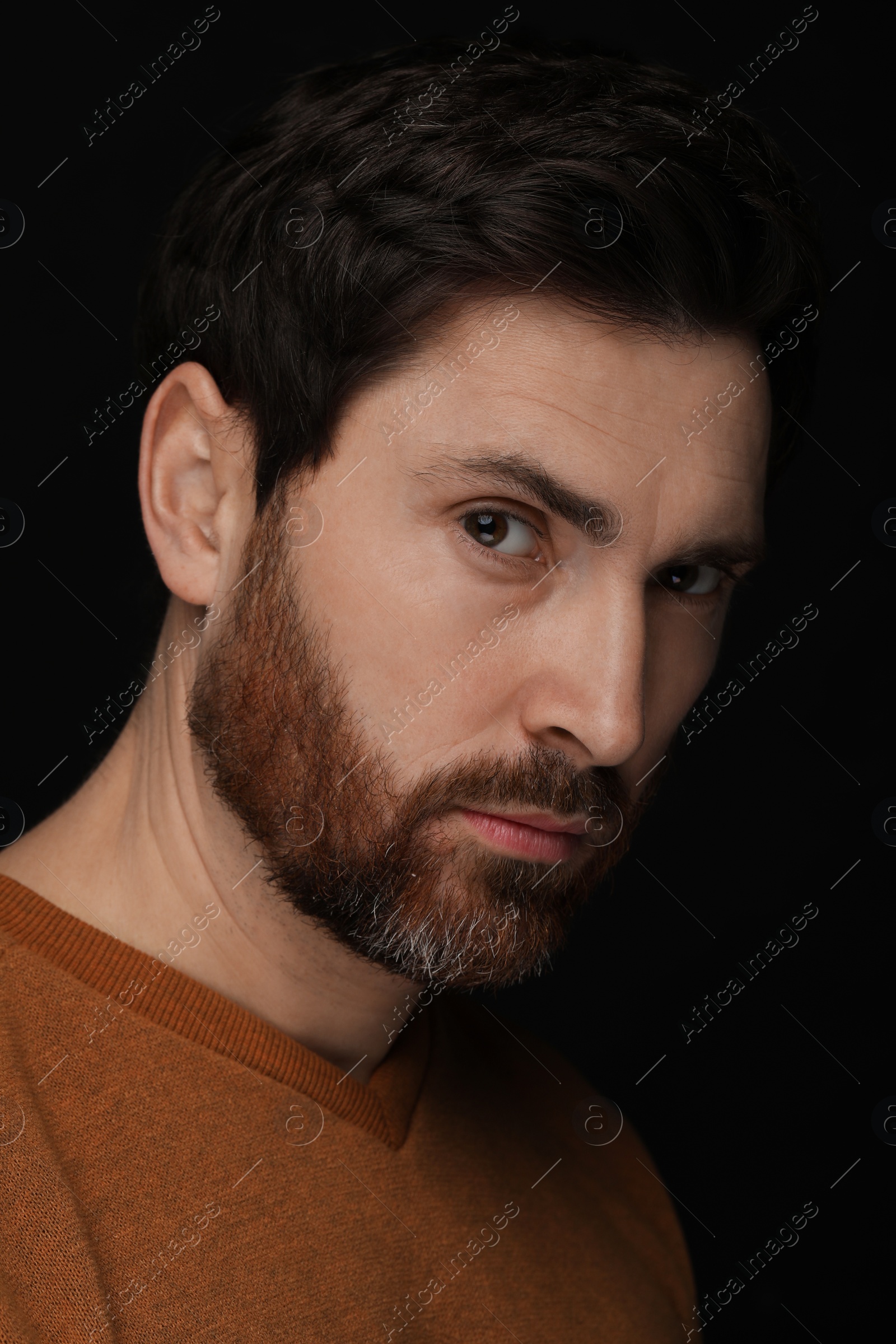 Photo of Evil eye. Man with scary eyes on black background, closeup