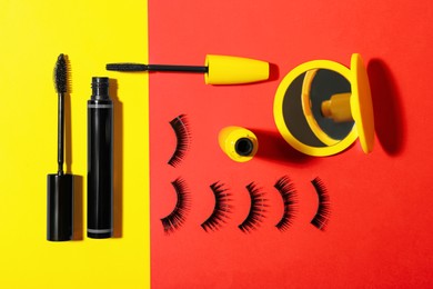 Photo of Different mascaras, fake eyelashes and mirror on color background, flat lay. Makeup product