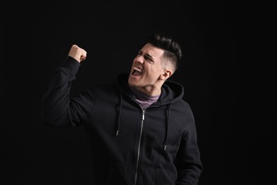 Photo of Portrait of emotional man on black background. Personality concept