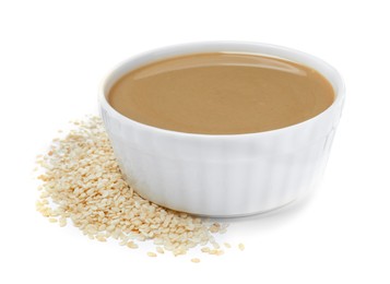 Tasty sesame paste in bowl and seeds on white background