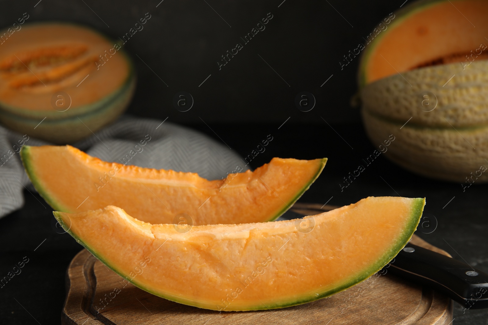 Photo of Slices of tasty fresh melon on wooden board, closeup