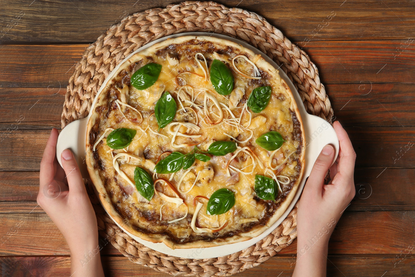 Photo of Woman holding tray with delicious homemade pizza on wooden background