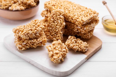 Puffed rice bars (kozinaki) on white wooden table, closeup