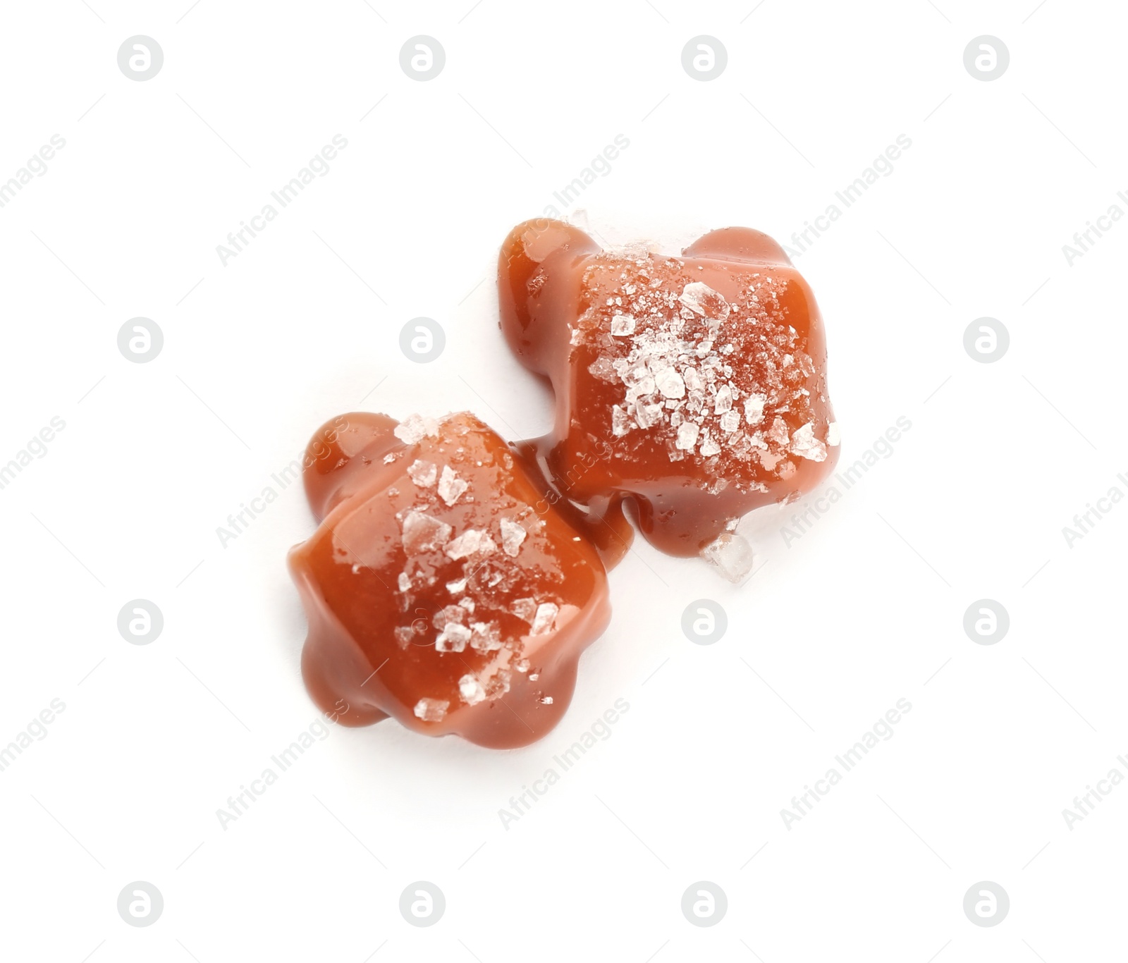 Photo of Delicious candies with caramel sauce and salt on white background, top view