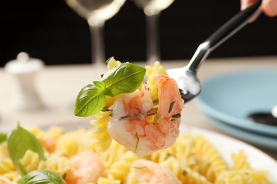 Photo of Woman eating delicious pasta with shrimps and basil, closeup