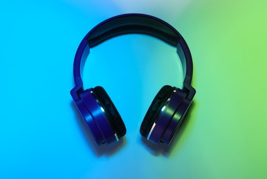 Stylish headphones on color background, top view