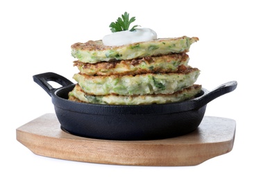 Delicious zucchini fritters with sour cream on white background