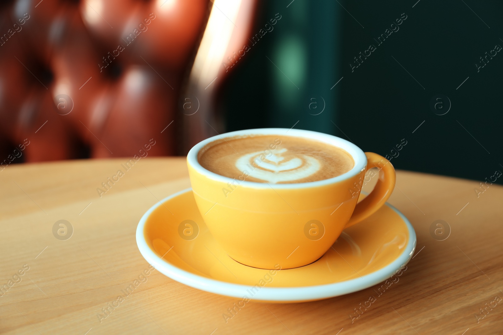 Photo of Cup of delicious coffee on wooden table indoors