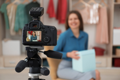 Fashion blogger recording new video in room, focus on camera