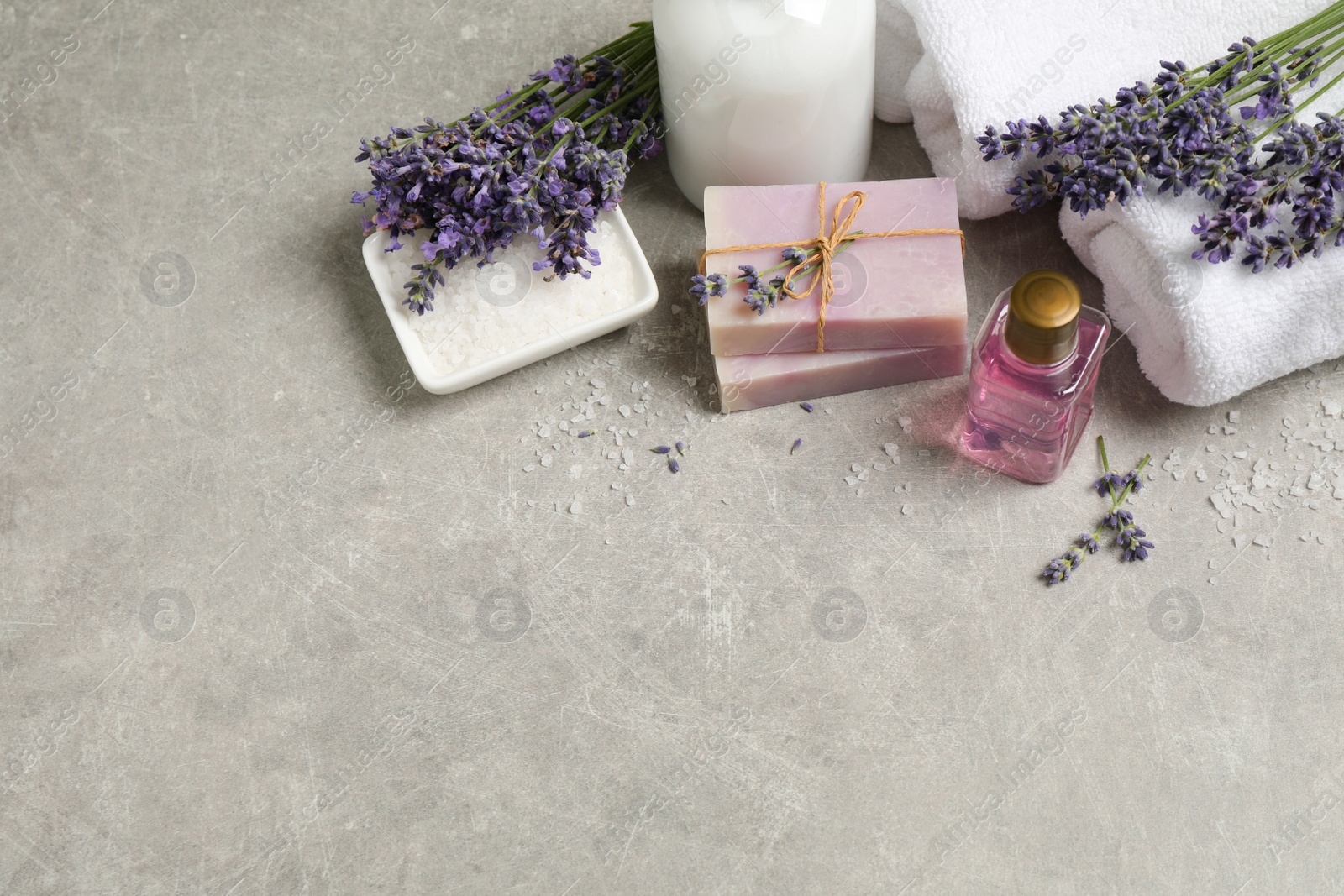 Photo of Cosmetic products and lavender flowers on light table. Space for text