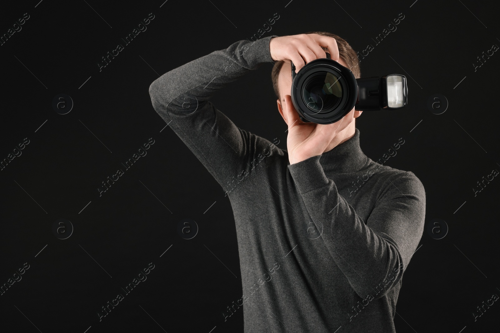 Photo of Professional photographer taking picture on black background