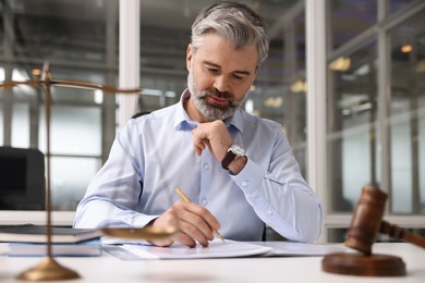 Portrait of handsome lawyer working at table in office