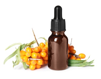 Natural sea buckthorn oil and fresh berries on white background