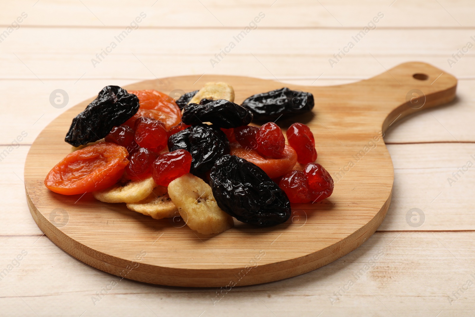 Photo of Mix of delicious dried fruits on white wooden table