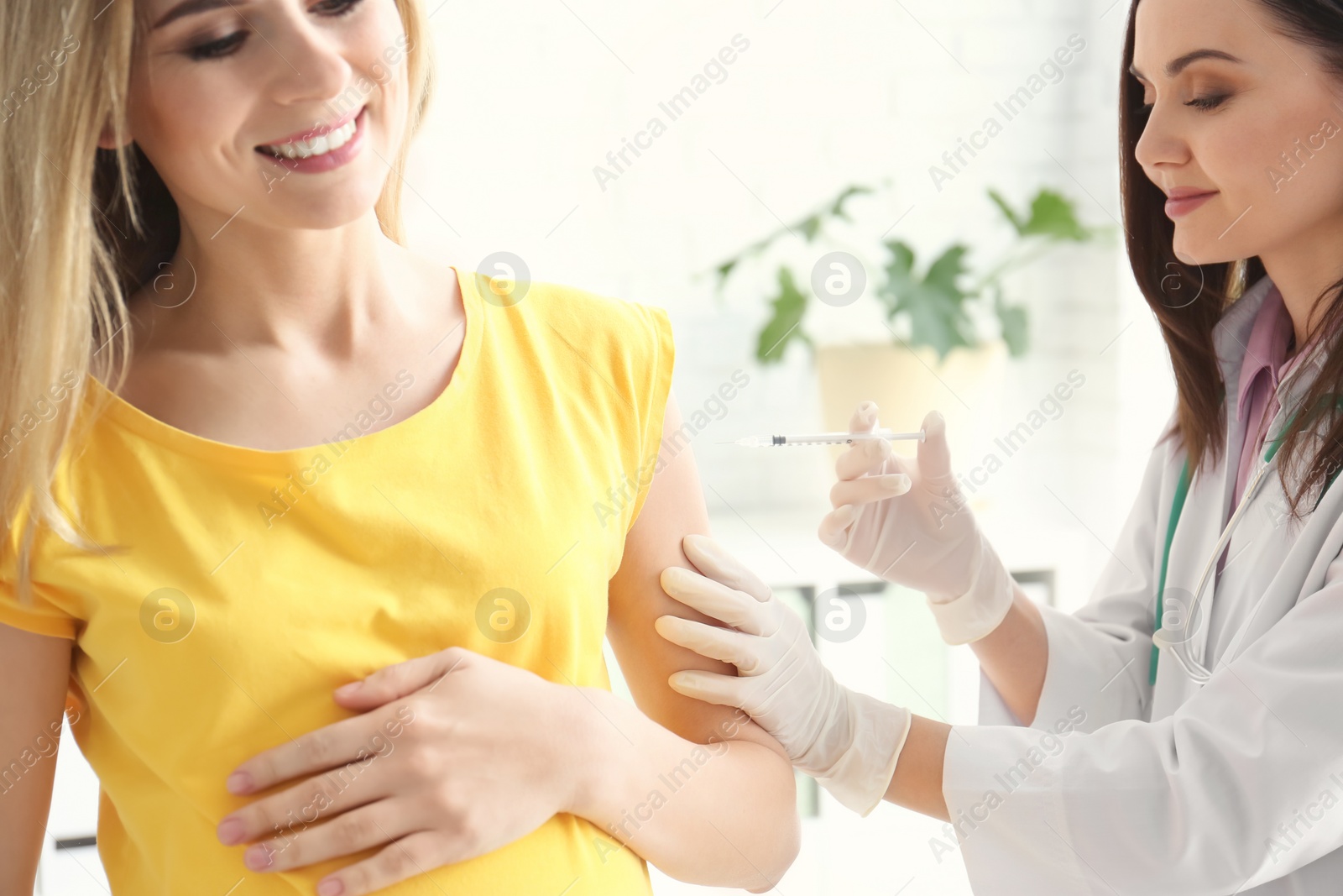 Photo of Doctor vaccinating pregnant woman in clinic