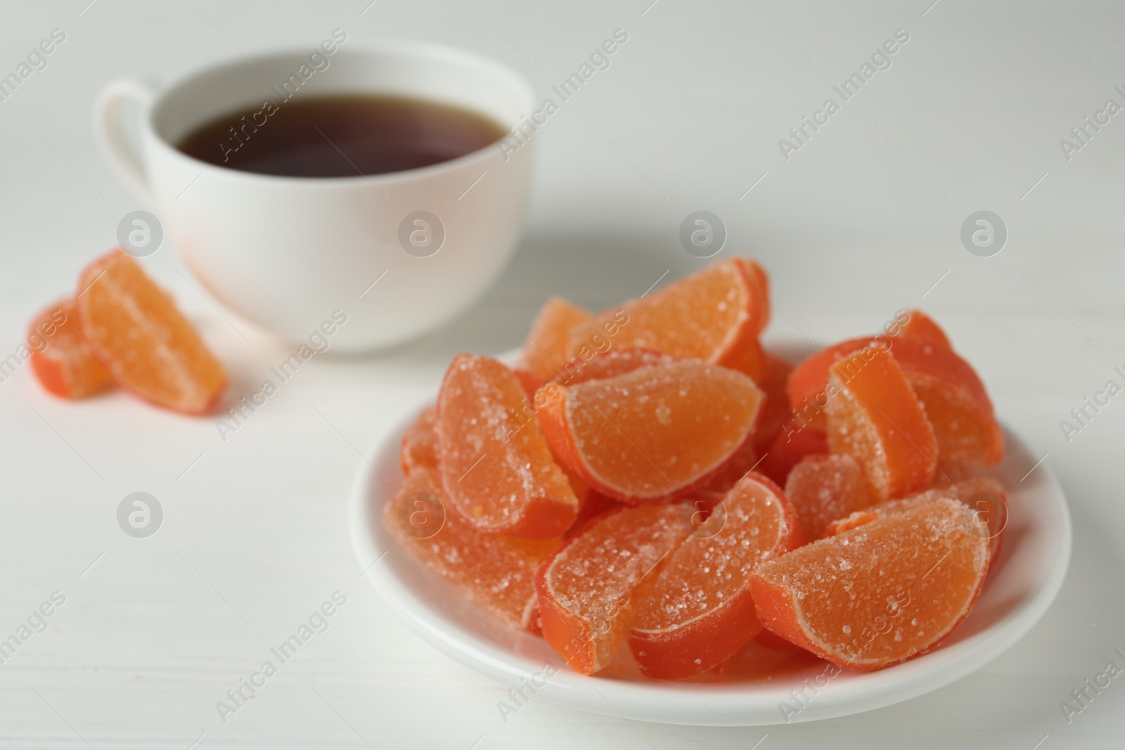 Photo of Tasty orange jelly candies on white table