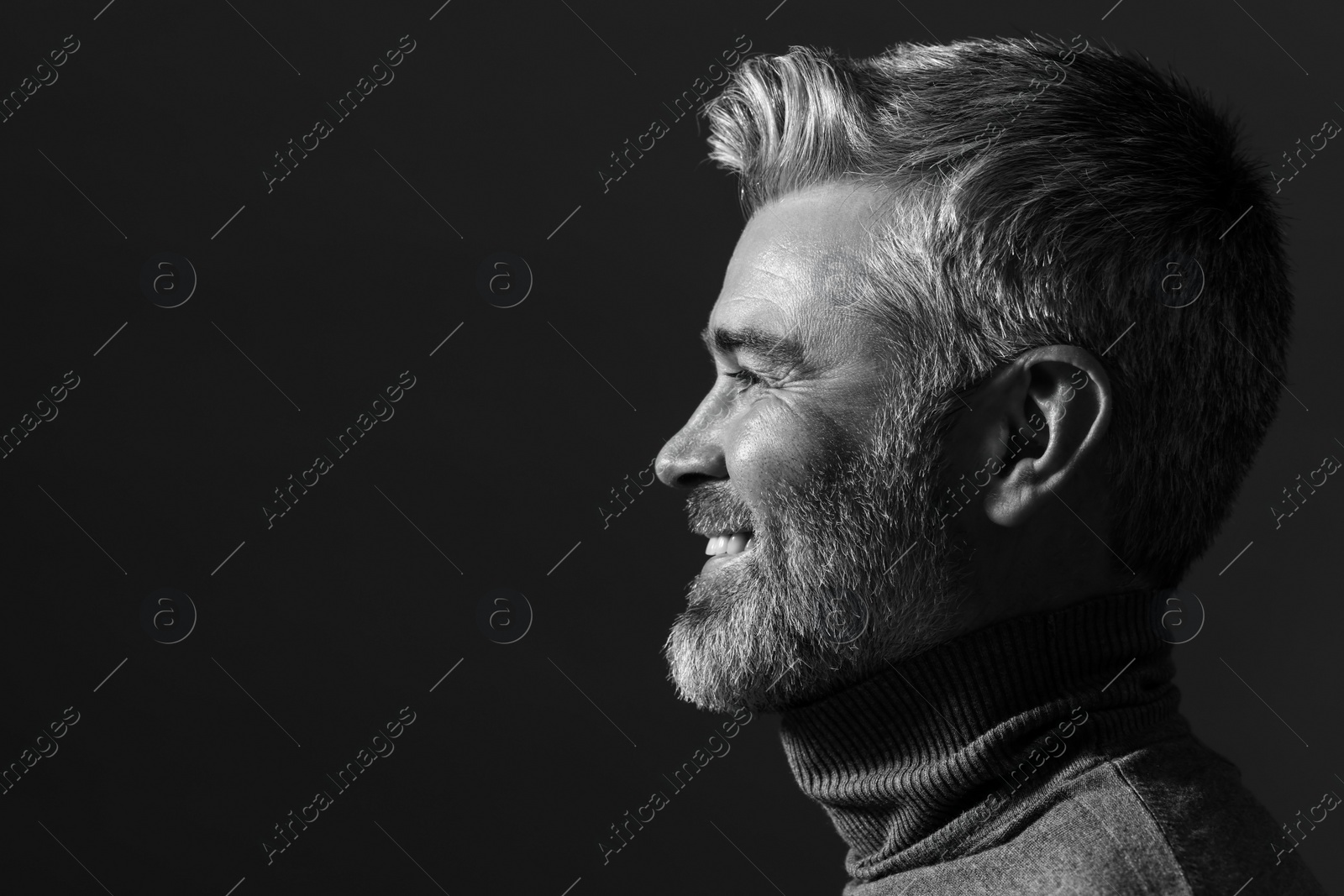 Photo of Portrait of smiling man on dark background, space for text. Black and white effect