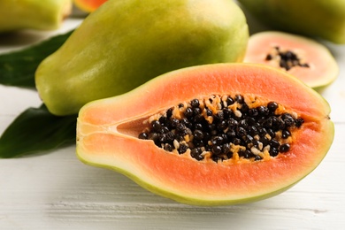 Photo of Fresh ripe papaya fruits on white table, closeup