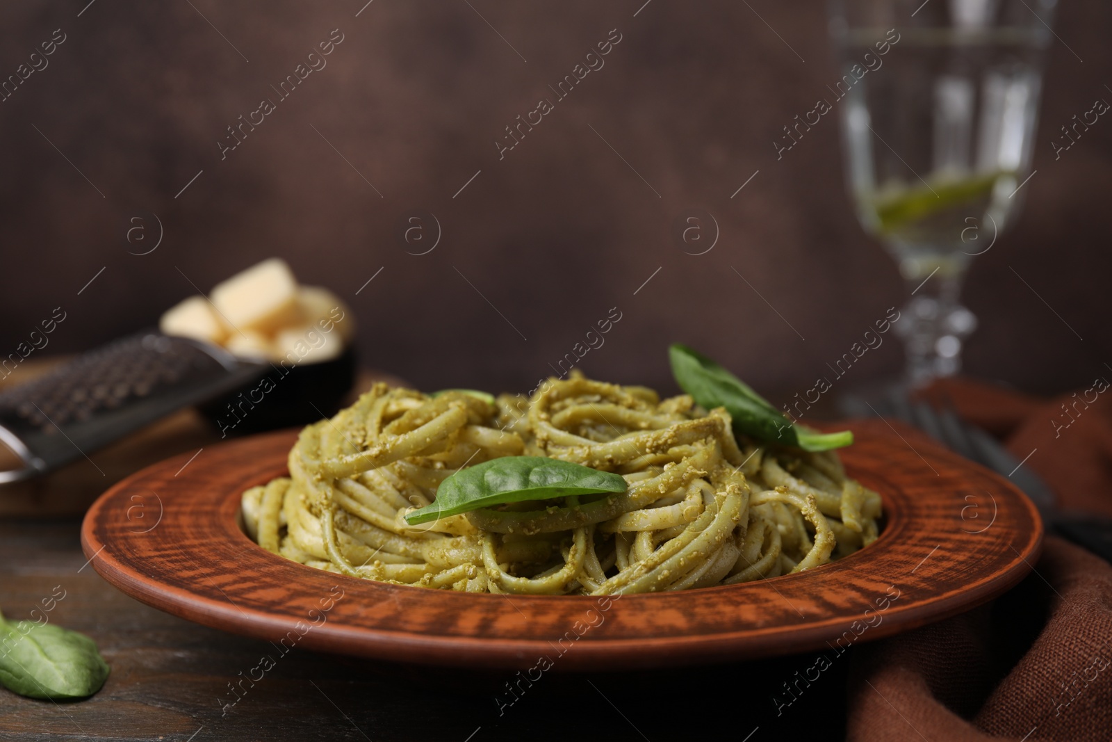 Photo of Tasty pasta with spinach on wooden table, closeup