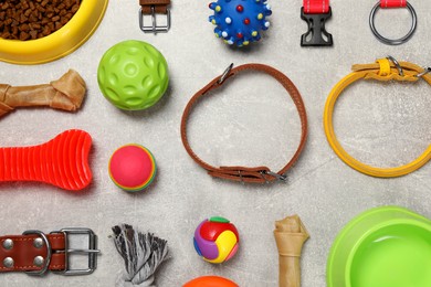 Photo of Flat lay composition with dog collars, toys and food on grey background