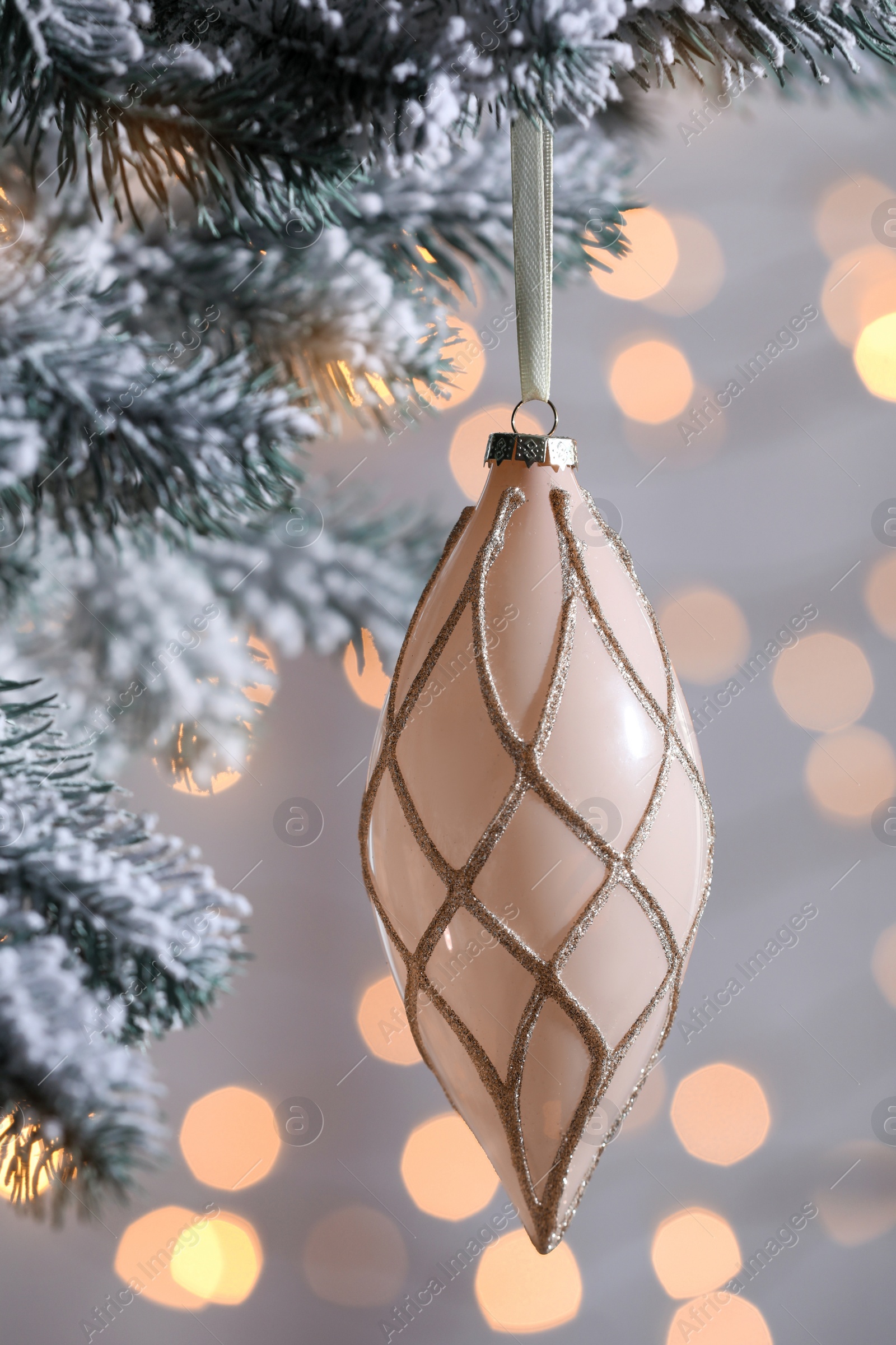 Photo of Christmas tree decorated with holiday bauble against blurred lights, closeup