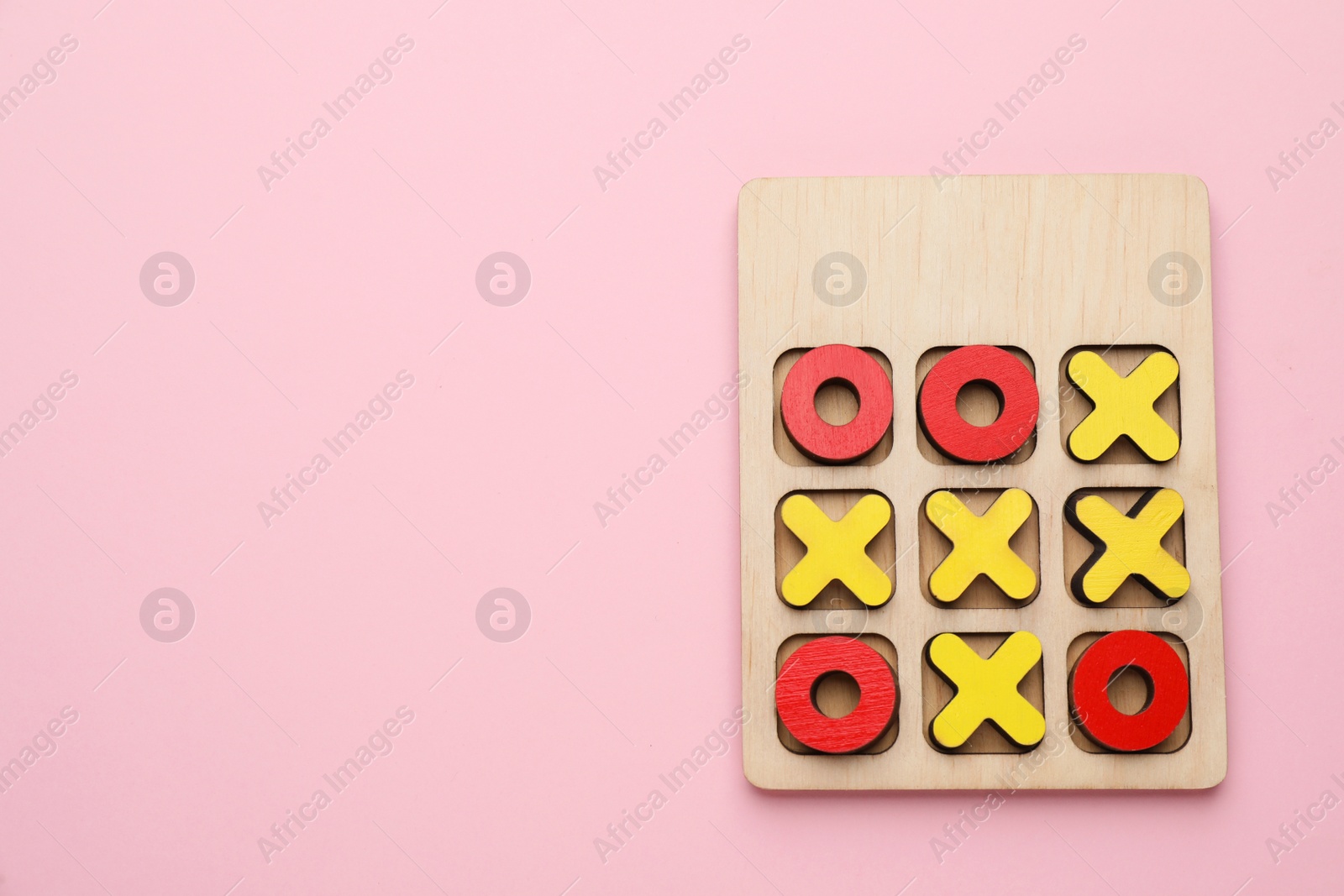 Photo of Tic tac toe set on pink background, top view. Space for text