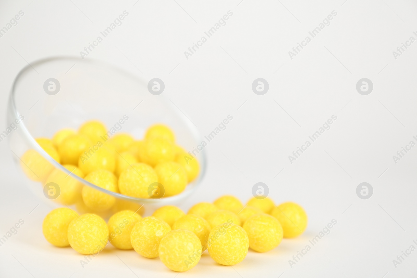 Photo of Tasty small lemon drops on white background