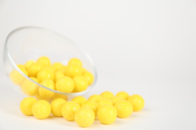 Photo of Tasty small lemon drops on white background