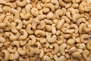 Photo of Many tasty cashew nuts as background, top view