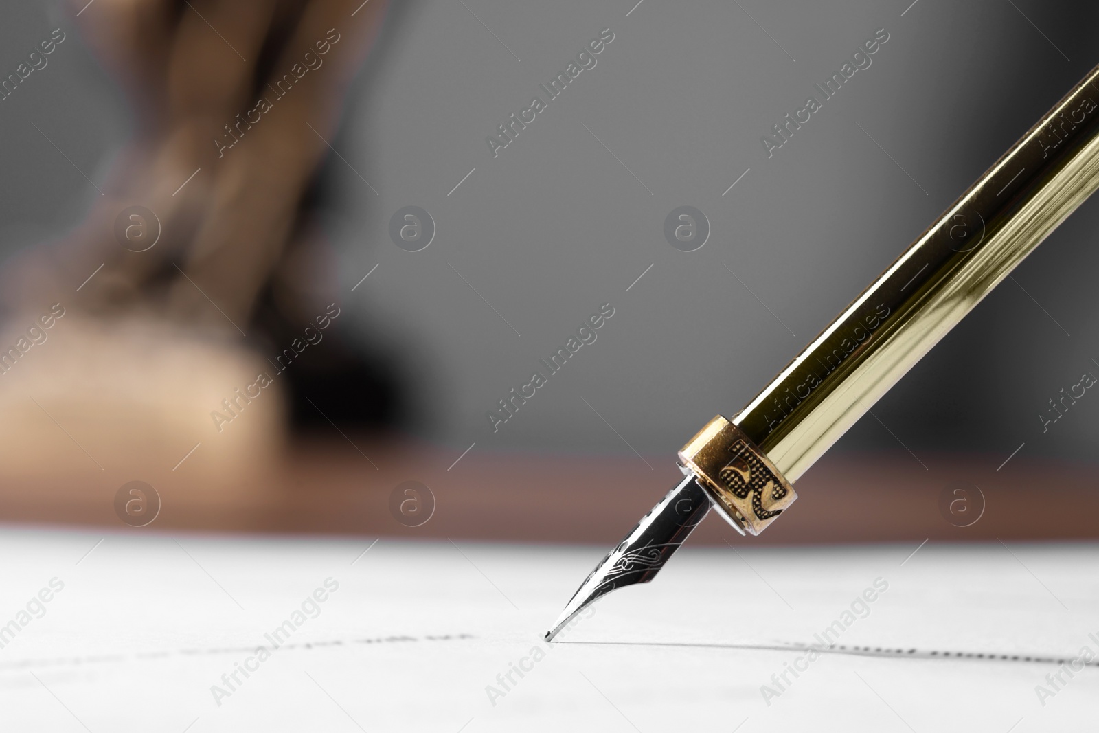 Photo of Writing on document with fountain pen at table, closeup and space for text. Notary contract